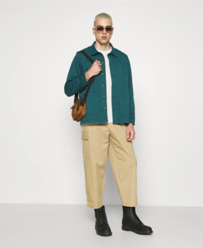 Fashion model in a teal jacket showcasing seasonal style